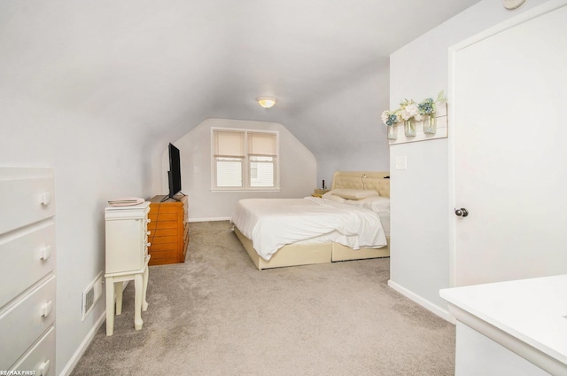 bedroom with light carpet, lofted ceiling, and baseboards