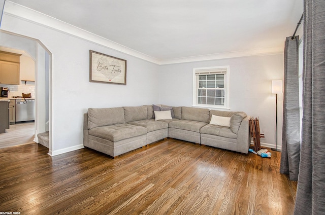 living area with baseboards, light wood finished floors, and crown molding