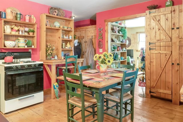 dining space featuring light wood finished floors and a barn door