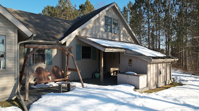 exterior space featuring a shingled roof, board and batten siding, and a wooden deck