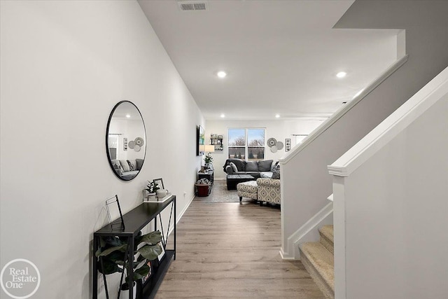 hallway featuring stairs, wood finished floors, visible vents, and recessed lighting