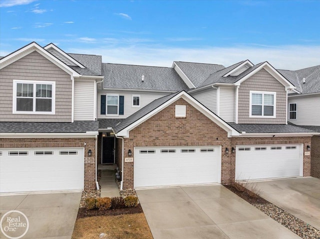 view of property with a garage, driveway, brick siding, and a shingled roof