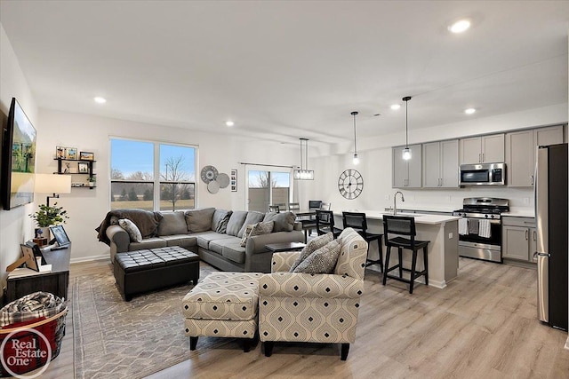 living room featuring light wood-type flooring, baseboards, and recessed lighting