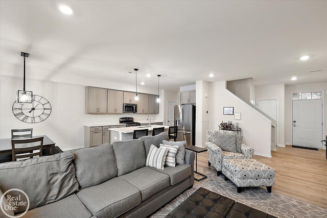 living room with light wood-type flooring, baseboards, and recessed lighting