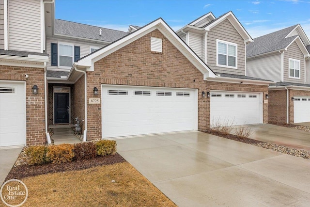 townhome / multi-family property featuring concrete driveway and brick siding