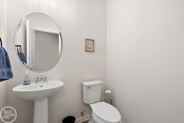 bathroom featuring baseboards and toilet