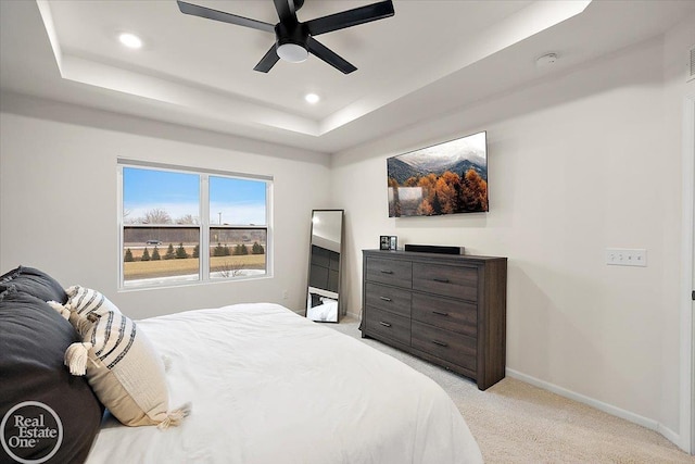 bedroom with recessed lighting, a raised ceiling, light colored carpet, a ceiling fan, and baseboards