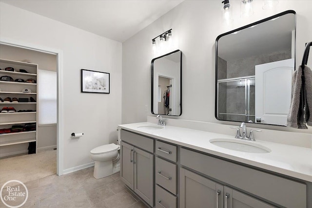 full bath featuring a spacious closet, a stall shower, a sink, and toilet