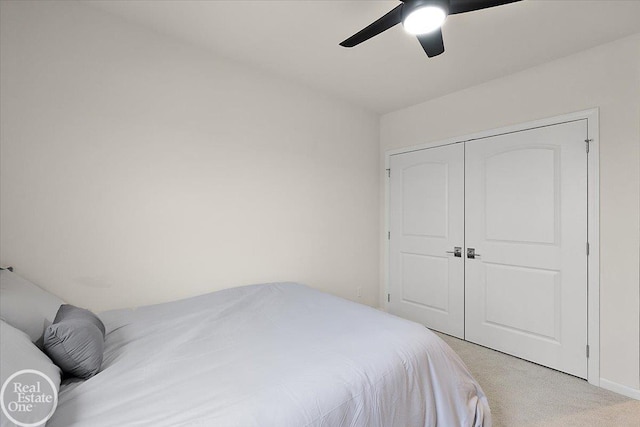 bedroom with light carpet, a closet, and a ceiling fan