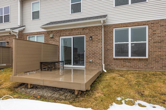 rear view of house with a deck and brick siding