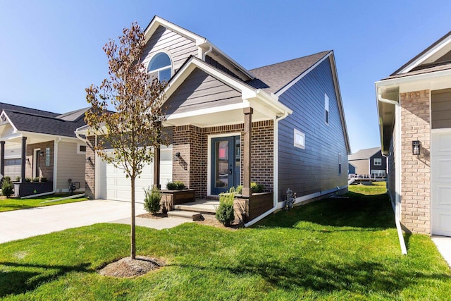 view of front of property featuring driveway, a garage, a front yard, and brick siding