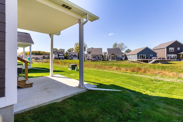 view of yard featuring a residential view and a patio