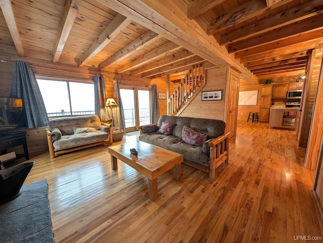 living room with light wood finished floors, wood ceiling, and wooden walls