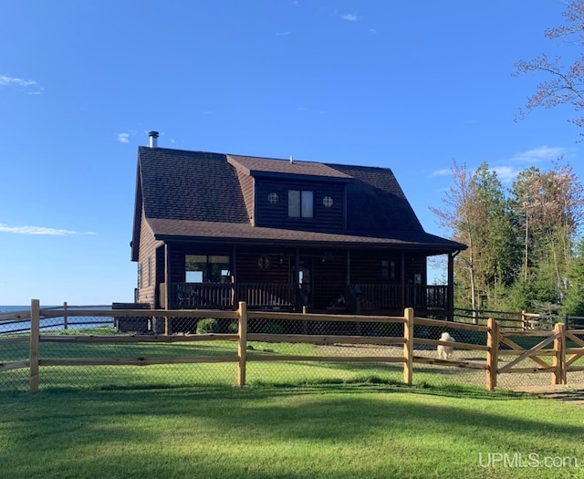 view of front of property with a front yard, log veneer siding, fence, and roof with shingles