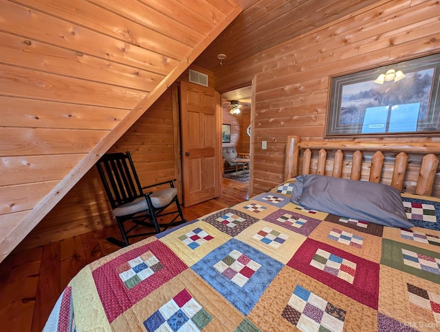 bedroom featuring wooden ceiling, visible vents, wooden walls, and wood finished floors