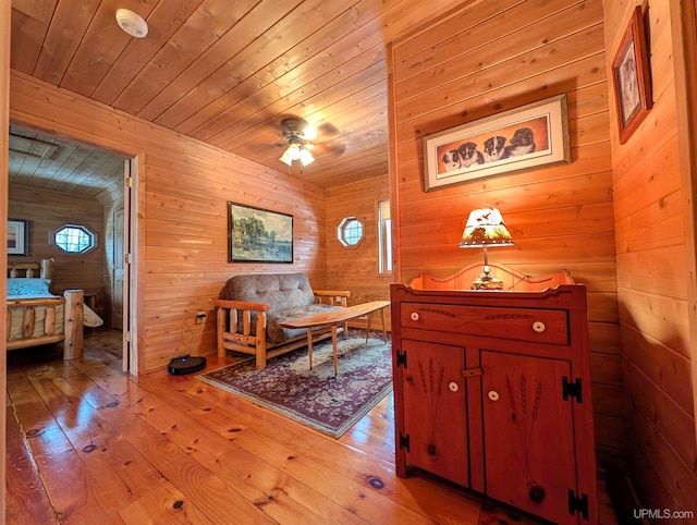 dining area featuring wood walls, hardwood / wood-style flooring, wood ceiling, and a ceiling fan