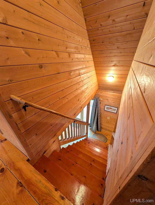 staircase featuring wood ceiling and wooden walls