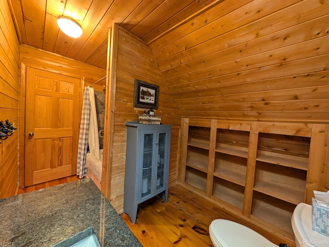 full bathroom featuring toilet, wood ceiling, wood walls, wood finished floors, and a shower with curtain