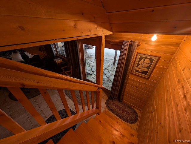 staircase featuring wooden ceiling, vaulted ceiling, wooden walls, and wood finished floors