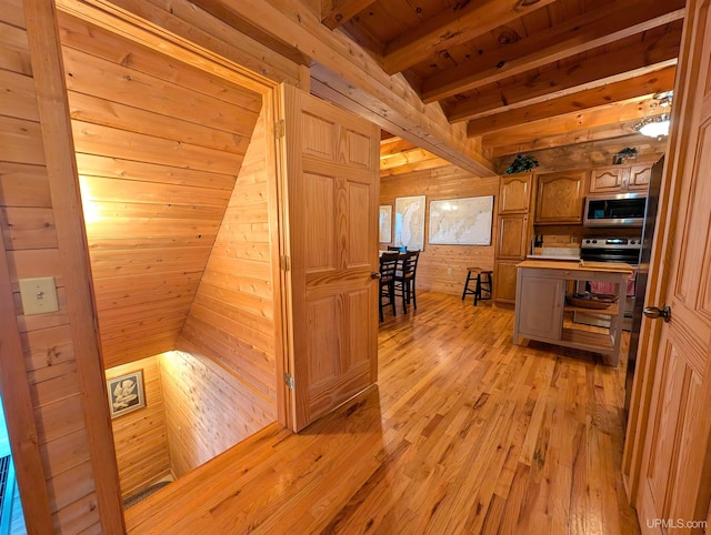 hallway featuring wood ceiling, light wood-type flooring, beam ceiling, and wooden walls