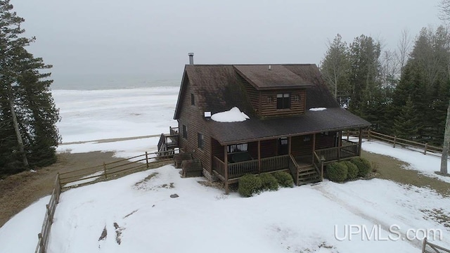 view of front of house featuring covered porch and fence