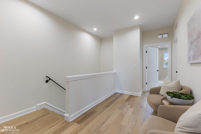 living area with recessed lighting, visible vents, an upstairs landing, baseboards, and light wood finished floors