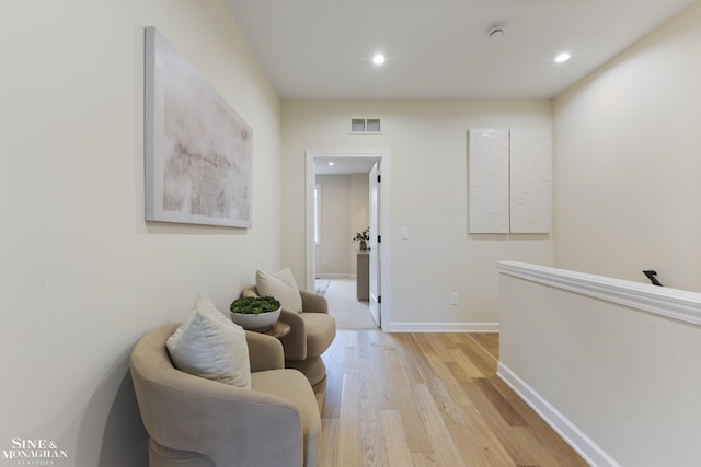 hall featuring light wood-style floors, recessed lighting, visible vents, and baseboards