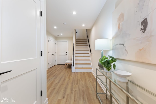 hall with stairs, light wood-style flooring, and recessed lighting