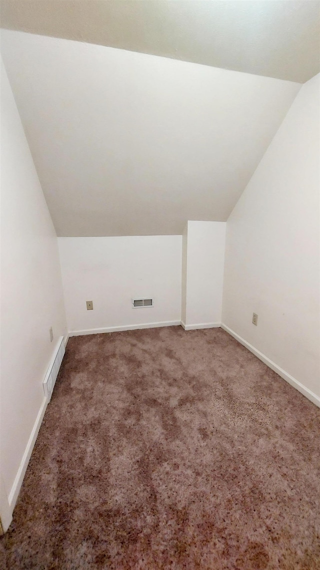 additional living space with lofted ceiling, carpet flooring, visible vents, and baseboards