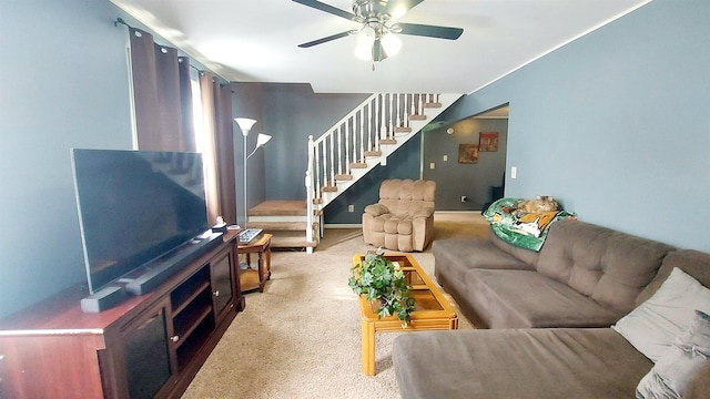 carpeted living area featuring ceiling fan and stairs