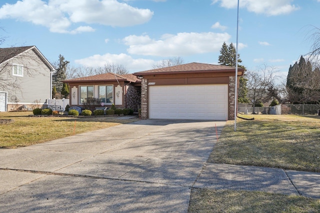 view of front of property with a front yard, fence, driveway, and an attached garage