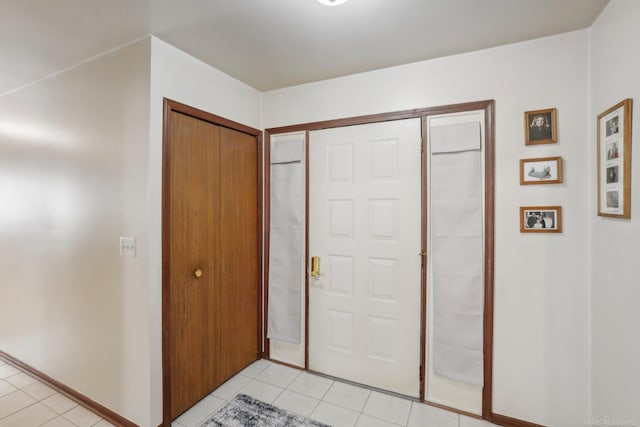 entrance foyer with baseboards and light tile patterned floors