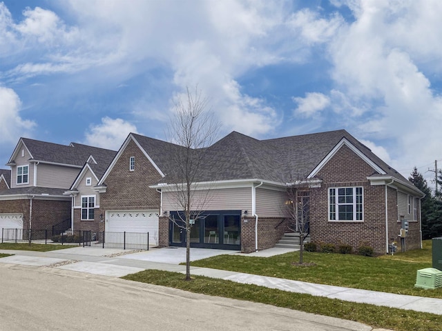 view of front of property featuring driveway, a front yard, fence, and brick siding