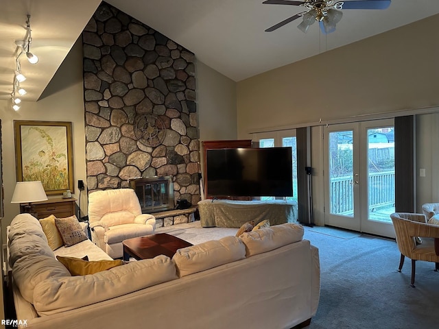 living room featuring high vaulted ceiling, a stone fireplace, carpet flooring, a ceiling fan, and french doors