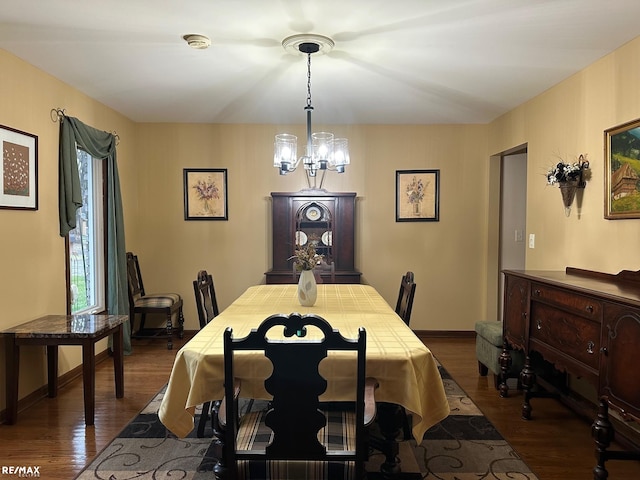 dining room featuring a chandelier, baseboards, and dark wood-style floors