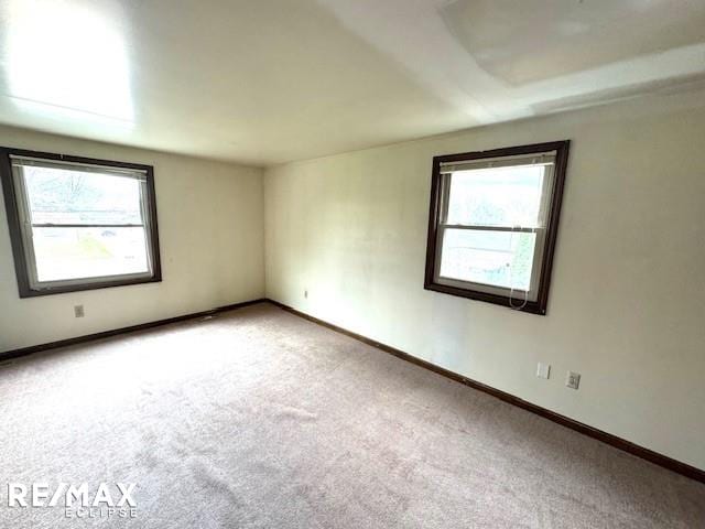 unfurnished room with carpet floors and baseboards