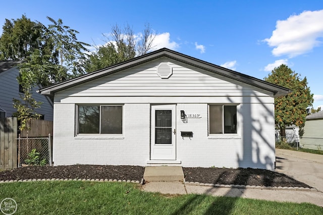 view of front facade featuring brick siding and fence