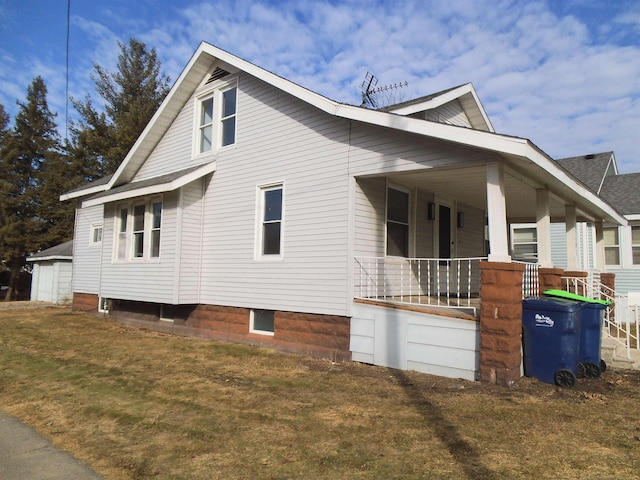 view of side of home with a porch and a lawn