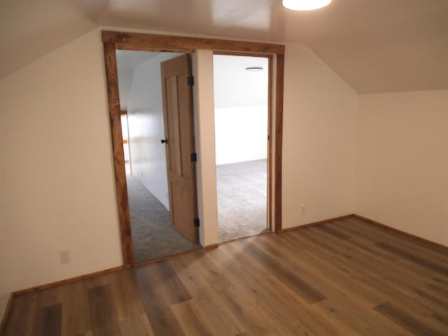 bonus room with baseboards, vaulted ceiling, and wood finished floors