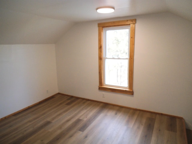 bonus room featuring lofted ceiling, baseboards, and wood finished floors