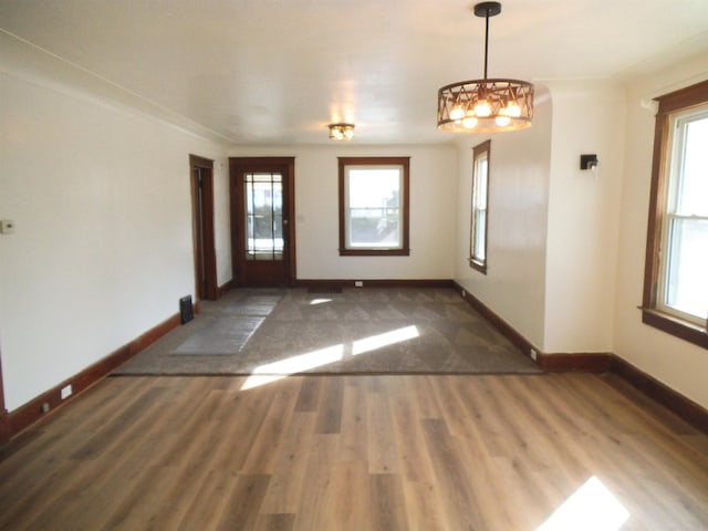 spare room featuring dark wood-style floors, plenty of natural light, and baseboards