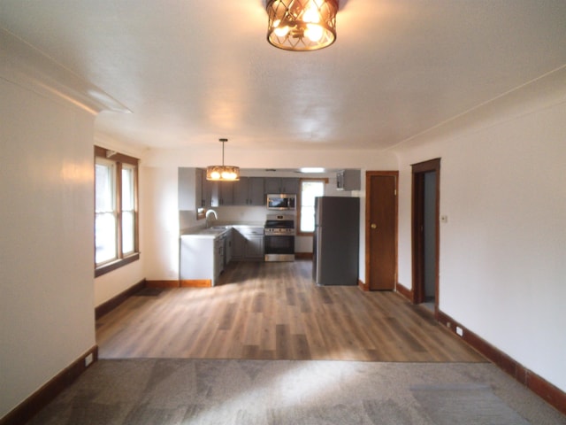 kitchen with baseboards, stainless steel appliances, and a sink