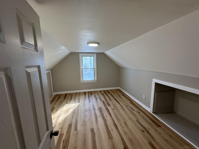 bonus room with vaulted ceiling, baseboards, and wood finished floors