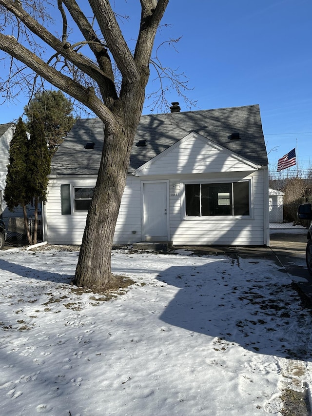 exterior space featuring a shingled roof and a chimney