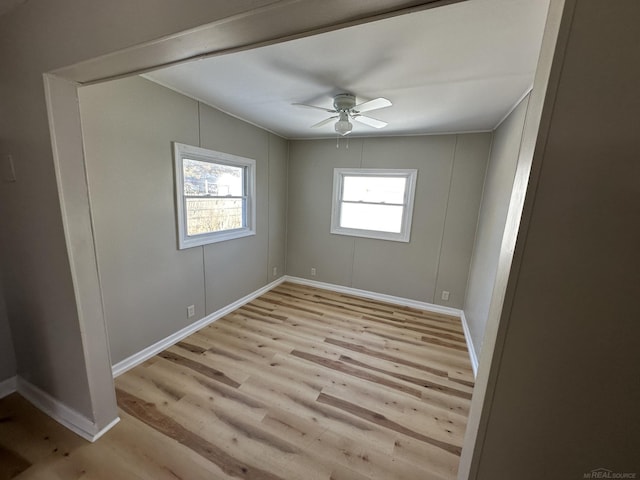 spare room featuring light wood-style flooring, baseboards, and ceiling fan