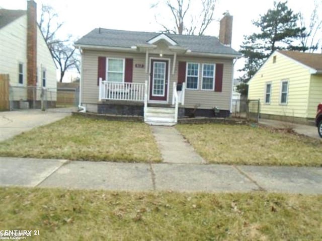 bungalow-style home featuring a porch, a chimney, and a front yard