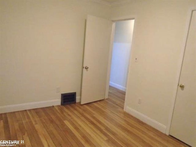 unfurnished bedroom with light wood-style flooring, visible vents, and baseboards