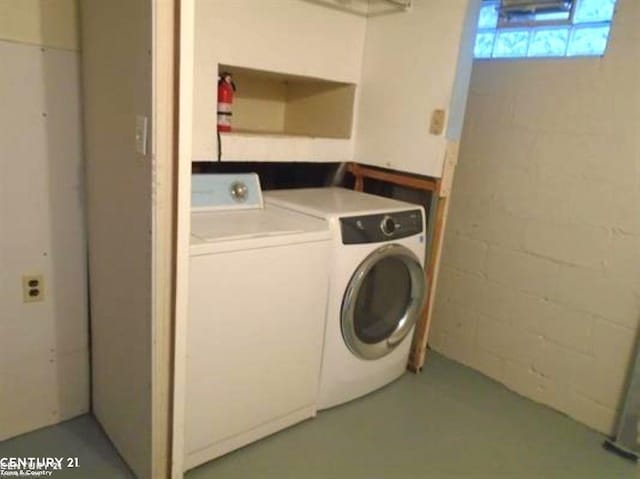 laundry area featuring washing machine and dryer, laundry area, and concrete block wall