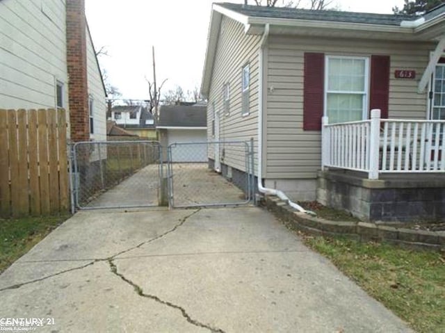 view of side of property with a gate, fence, and a detached garage