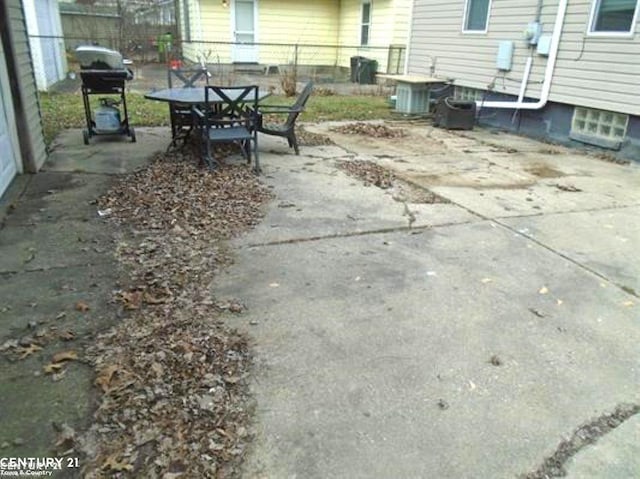 view of patio / terrace featuring outdoor dining space, central AC, fence, and area for grilling